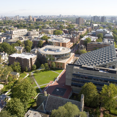 An aerial view of Gund Hall and surrounding buildings on a sunny afternoon.