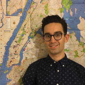 picture of Adam Tanaka standing in front of a map of Manhattan