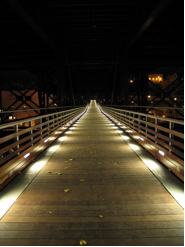 Marsupial Bridge at night with lights running along the interior edges of the bridge.