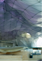 A puple and white geometric ceiling with wooden floors below.