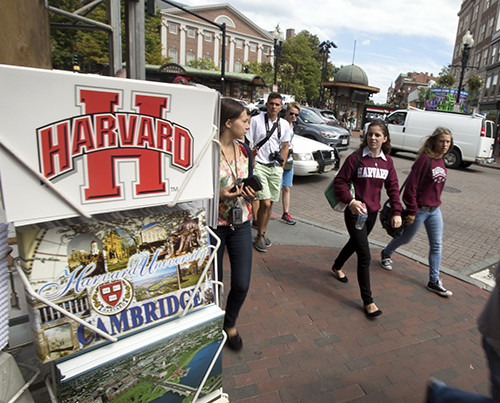 Students walk past a store selling Harvard merchandise.