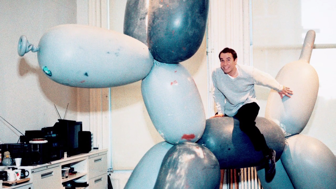 Jeff Koons astride one of his sculptures.