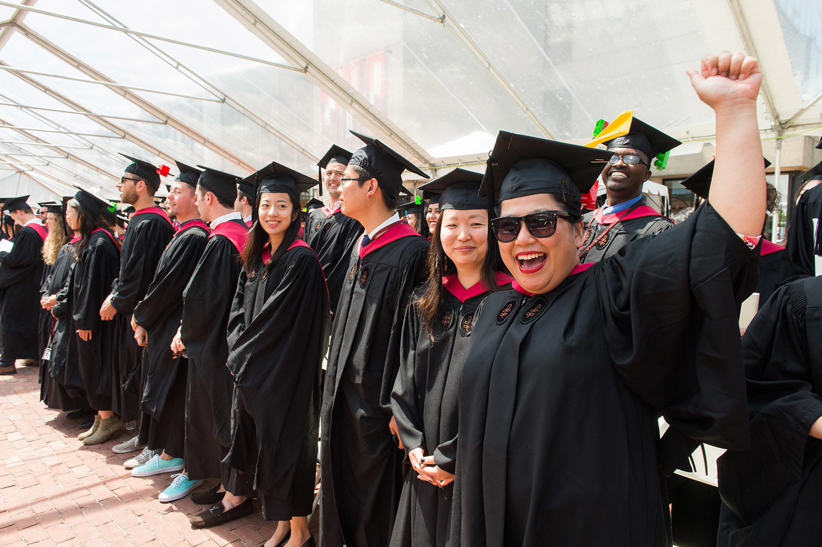 Graduates in regalia celebrate at the end of Commencement ceremonies