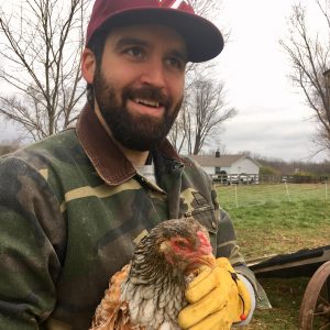 picture of Jonathan Grinham smiling and holding a chicken