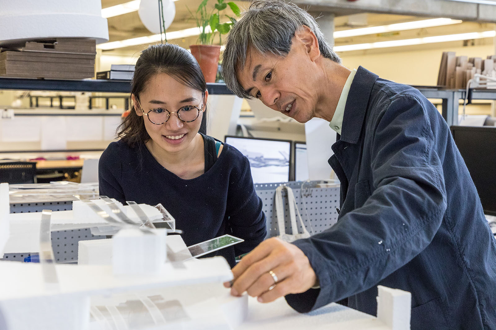 A student and faculty member examine a student project together.