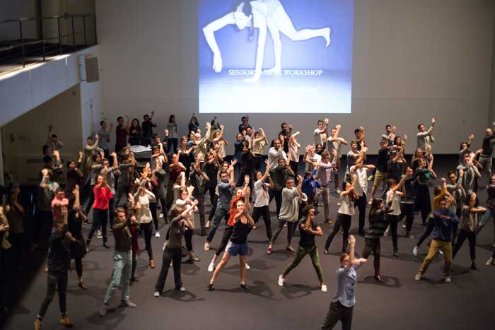 A large group of students perform a dance.