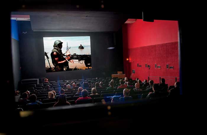 Students watch a film screening in a theater.