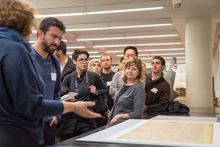 A group of people look at an item from the library's special collections.