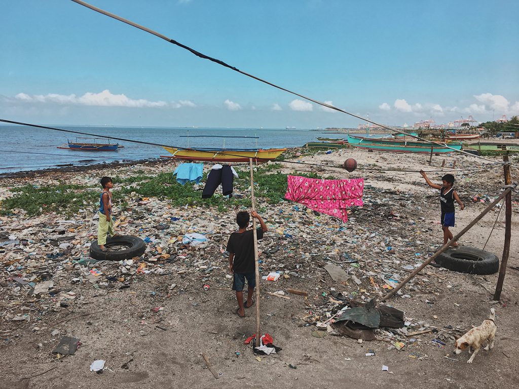Over half the population of the Philippines is under the age of 23. Here, a few boys play on a heap of trash that sets the foundation of the land they live on.