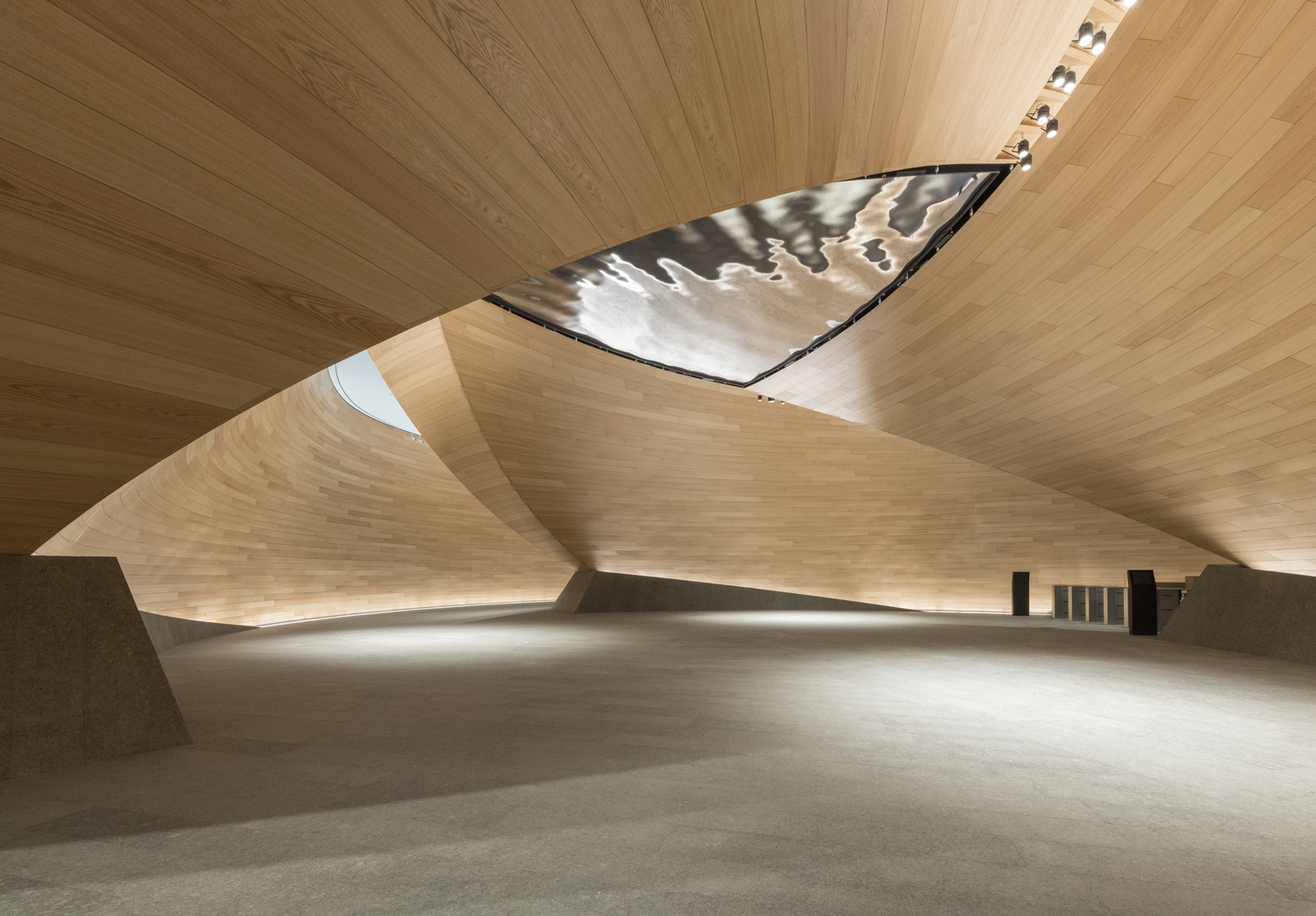 The main reception are leads to the "Vortex," a dramatic, double-height space created by three curved timber shells