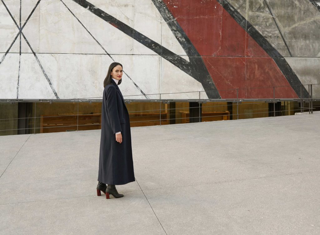 Portrait of Frida Escobedo in front of a mural.