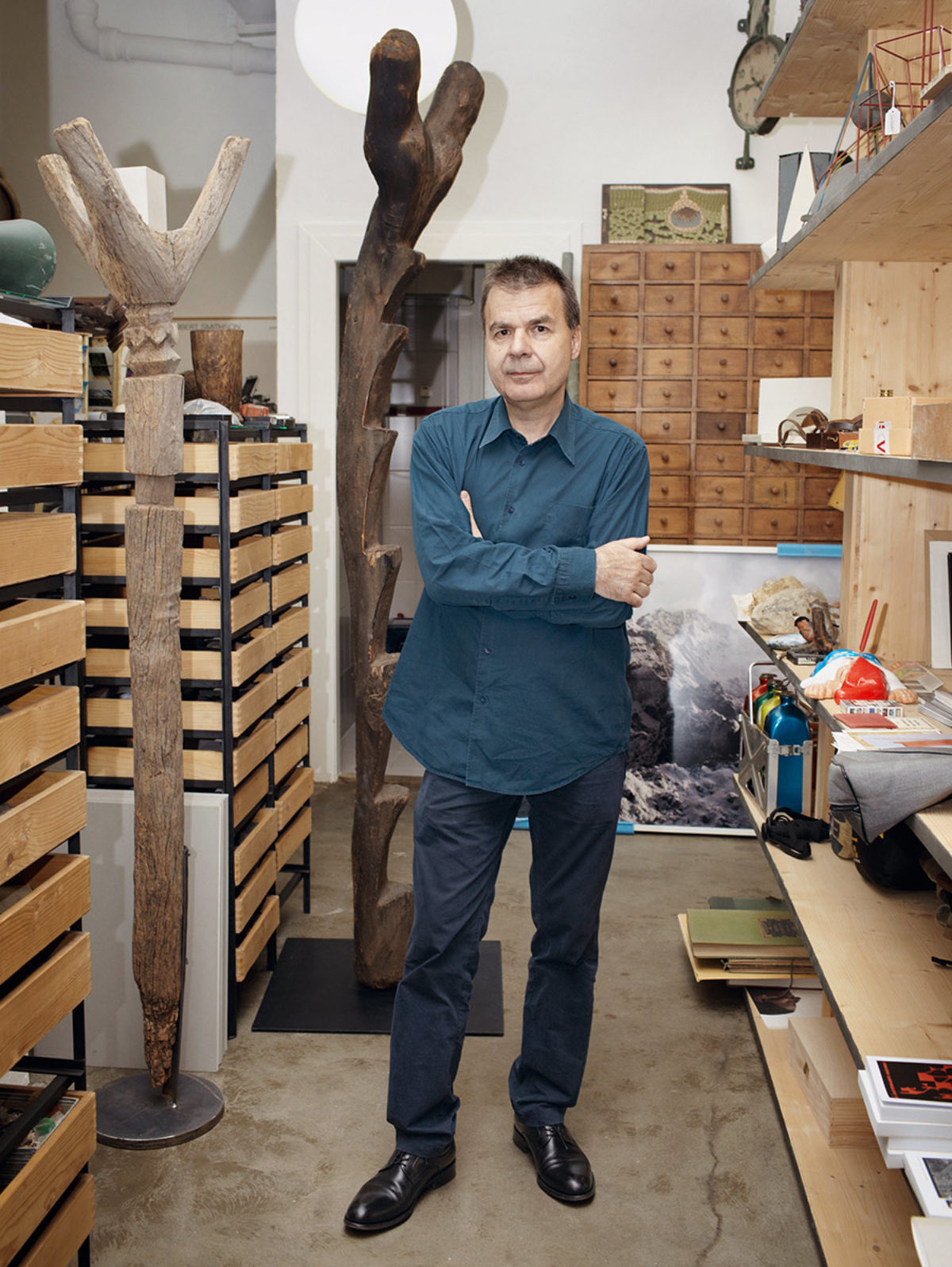 Günther Vogt standing in his workshop surrounded by shelving
