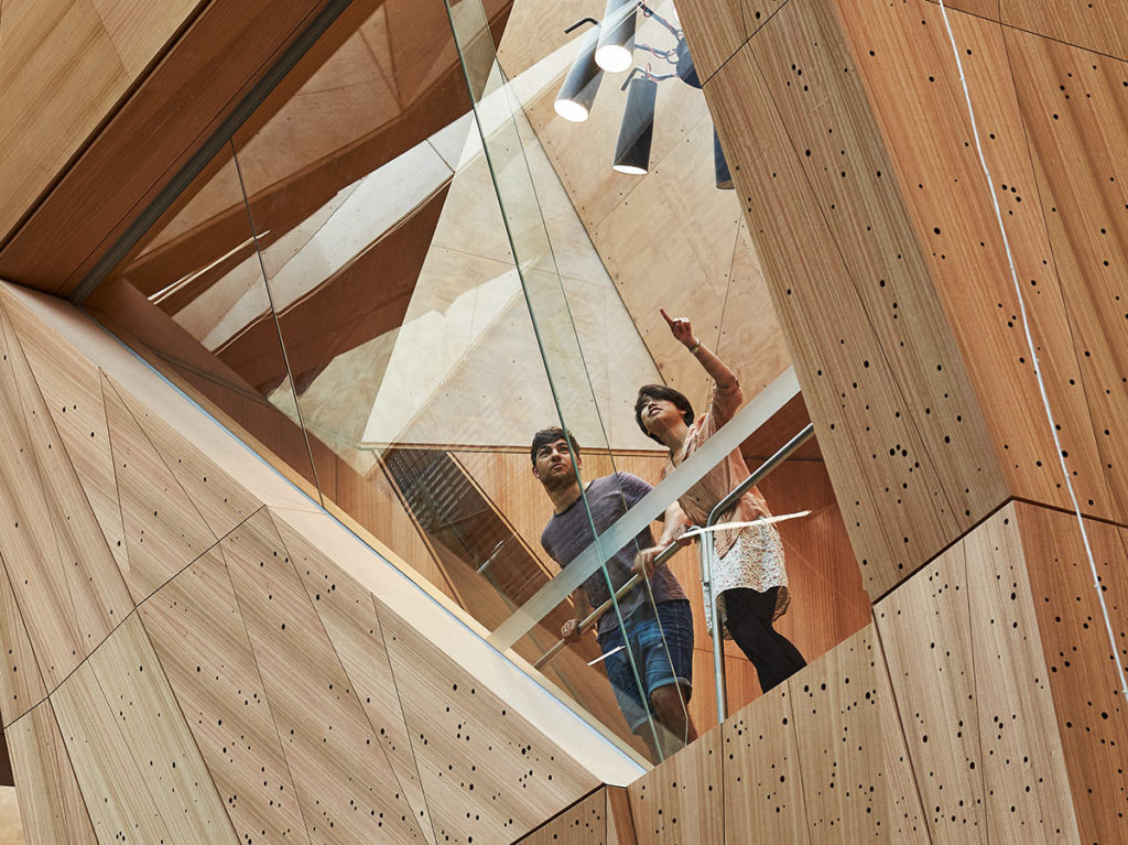 Two people looking through window with wooden frame