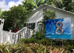 Artist Xavier Cortada's studio in Pinecrest, with an "Underwater HOA" sign indicating how much sea rise will submerge the property