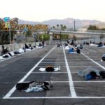 Homeless people sleep in a temporary parking lot shelter at Cashman Center
