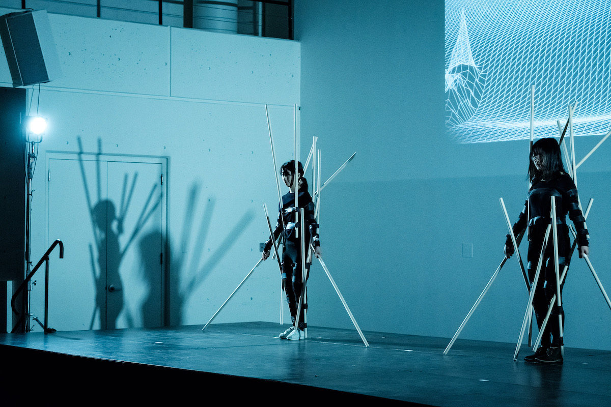 Two women on a stage in costumes.