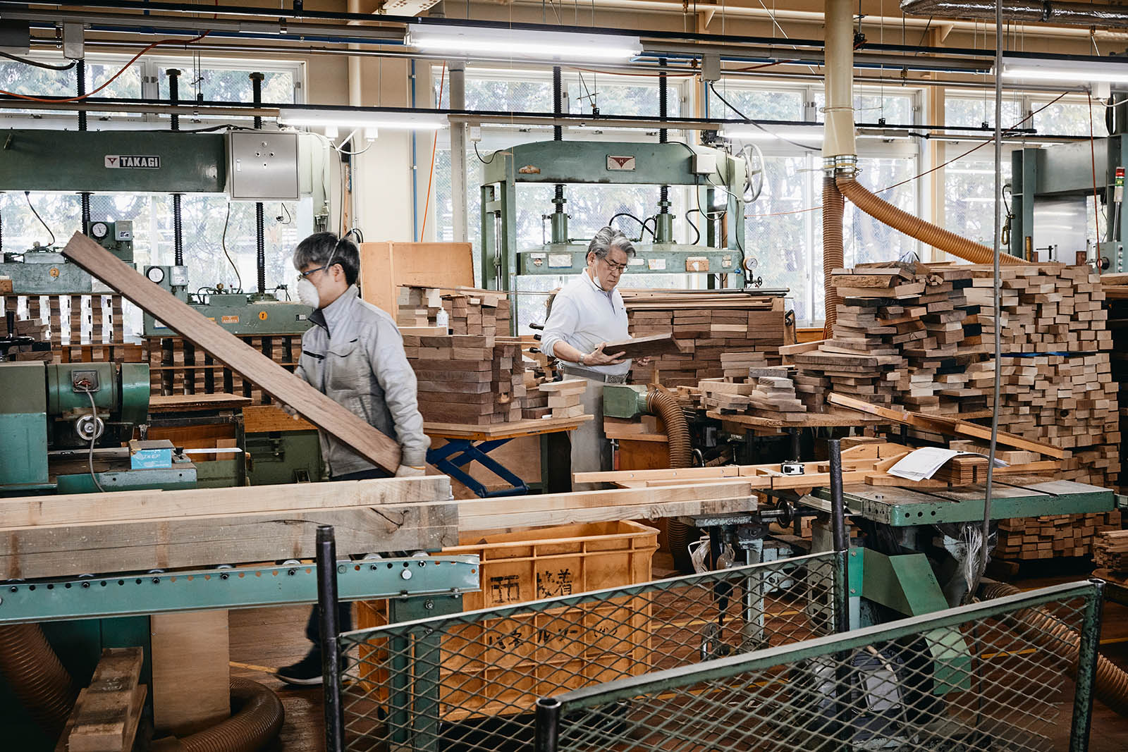 Workers in production area sorting wood planks