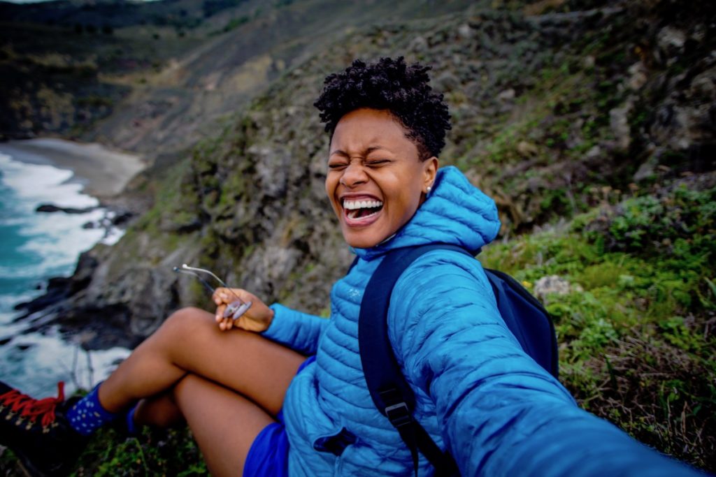 Selfie of L. Blount smiling on a mountain.