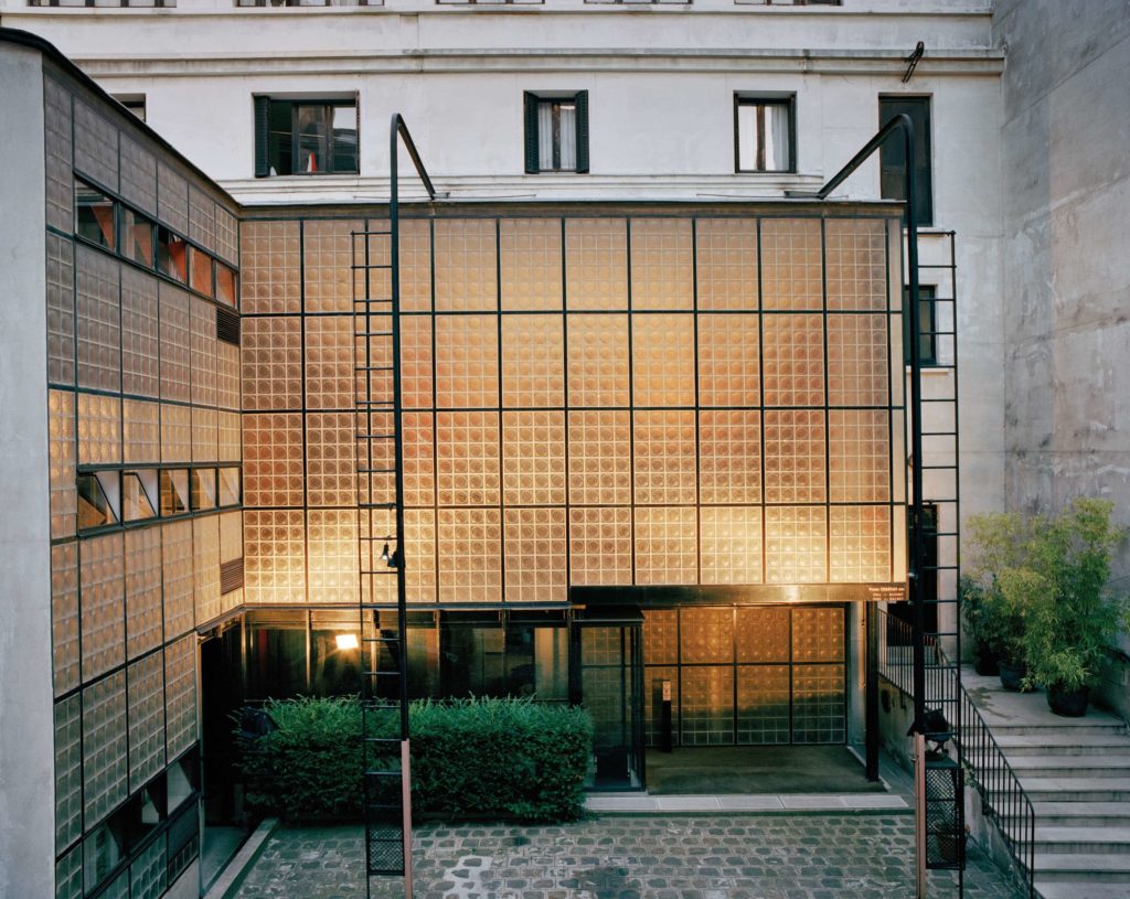 Image of photograph showing the elevation of Maison de Verre with glowing light in the interior