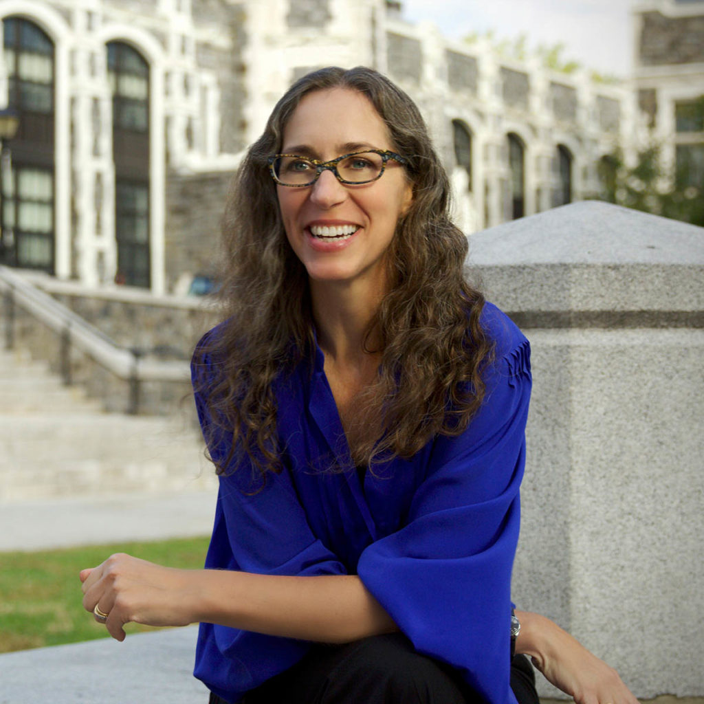 Headshot of Catherine Seavitt Nordenson, who wheres a blue shirt and glasses and has long wavy brown hair.