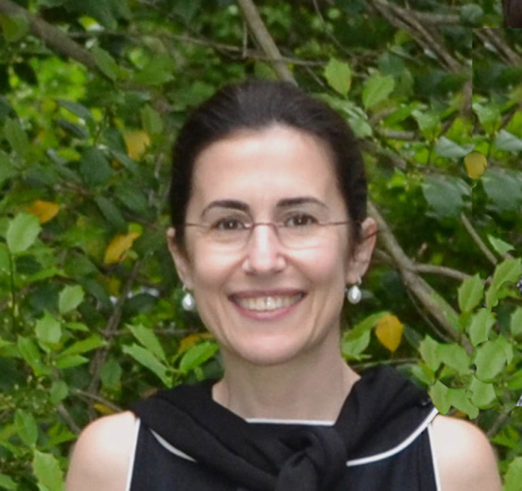 Headshot of Raffaella Fabiani Giannetto, who wheres a black shirt, glasses, and small white earrings, and has brown hair.