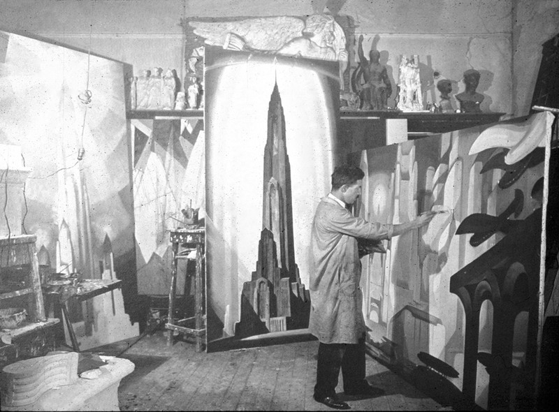 Black and white image of Ferris in studio with an iconic illustration of the metropolis behind him