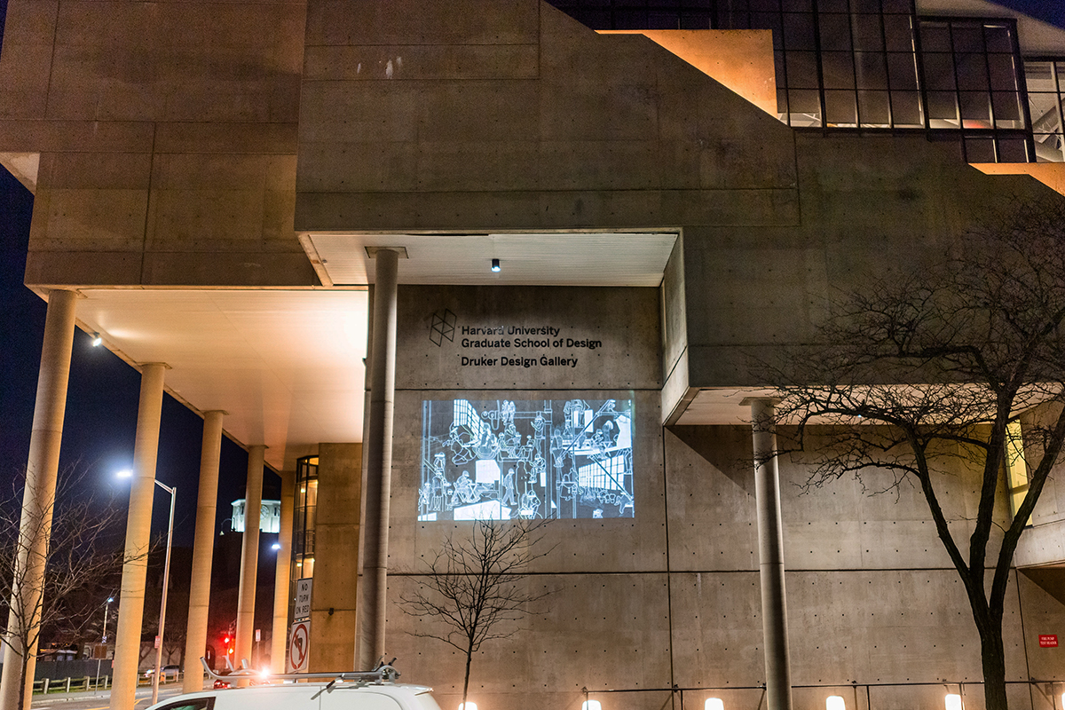 The Cambridge Street facade of Gund Hall at night, showing a projection from "The Redacted Block"