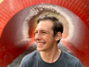 Headshot of David Bemporad in front of a colorfull background.