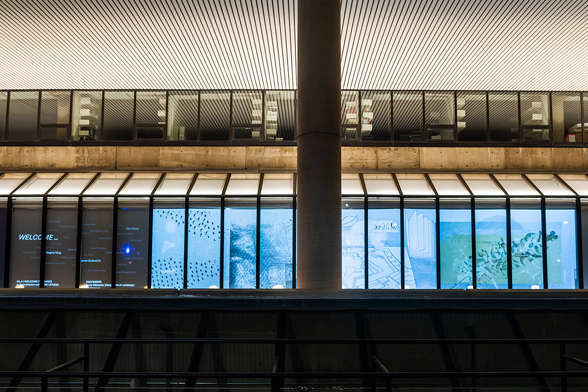 The Quincy Street facade of Gund Hall, showing a projection in the windows of Landscape Architecture welcome kits.