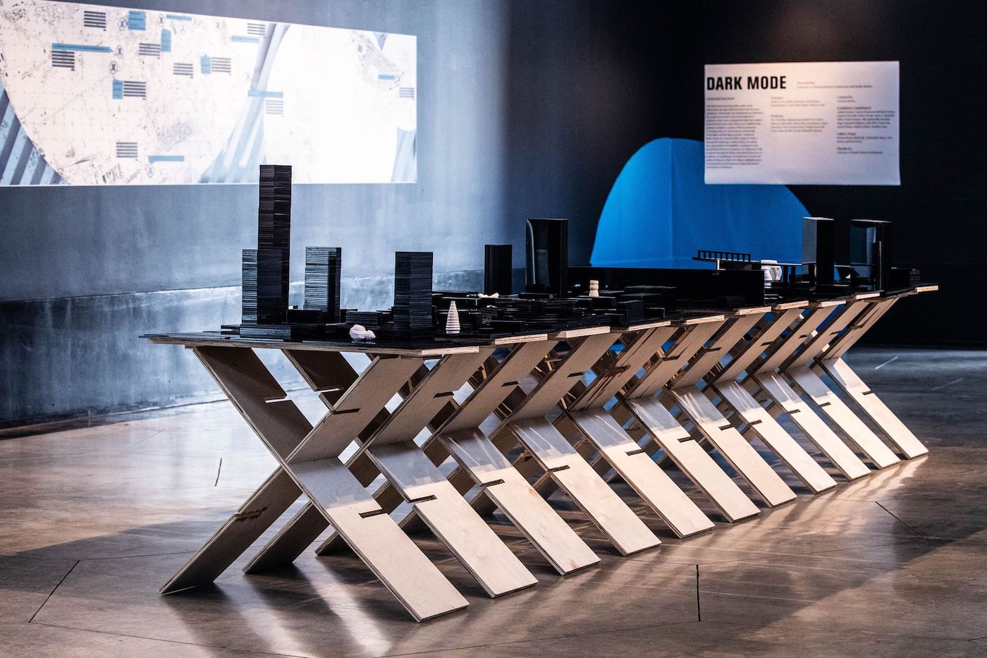 Architecture exhibition with building models on a table.