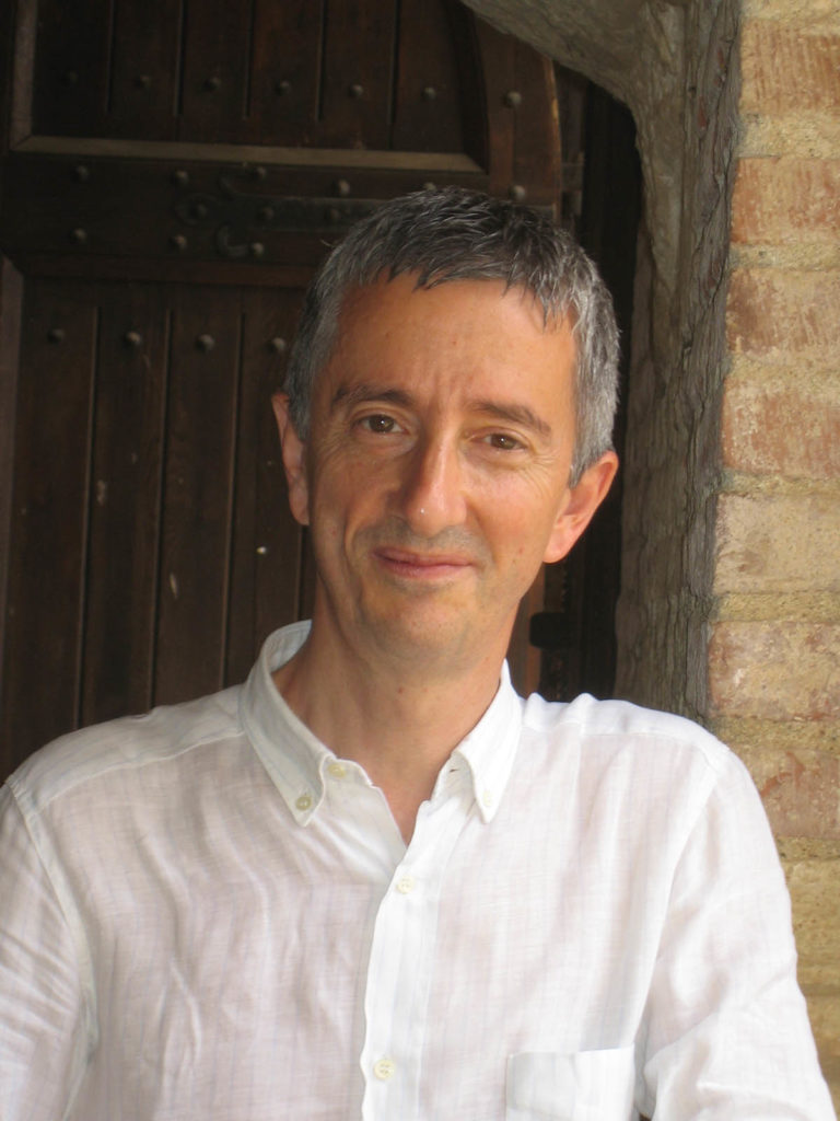 Headshot of Vittorio Lampugnani who wears a white collared shirt and has short gray hair. There is a brick column behind him.