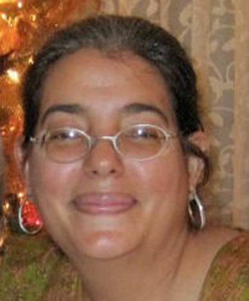 Headshot of Pauline Kulstad-González, who wears glasses and hoop earrings.