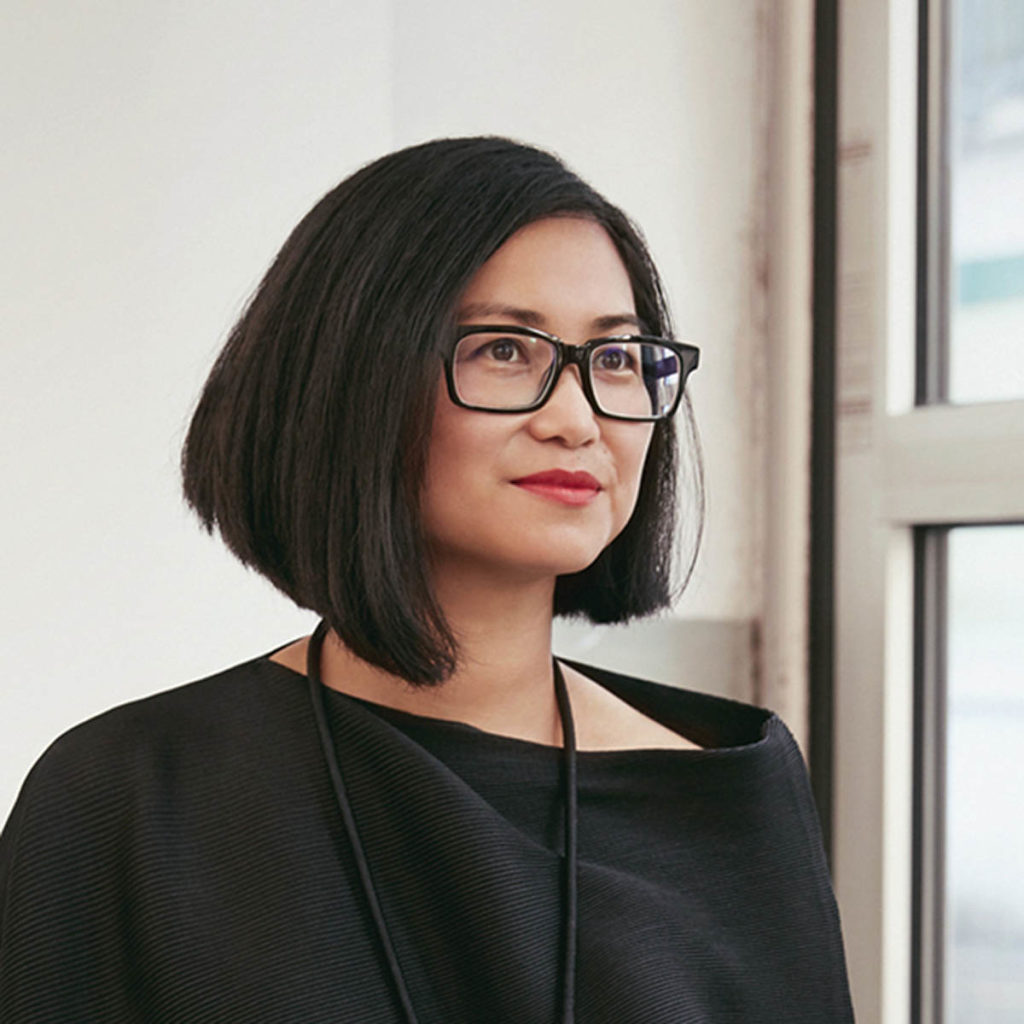 Headshot of Jeannette Kuo, who wearss a black top and black glasses, and has chin-length dark brown hair.