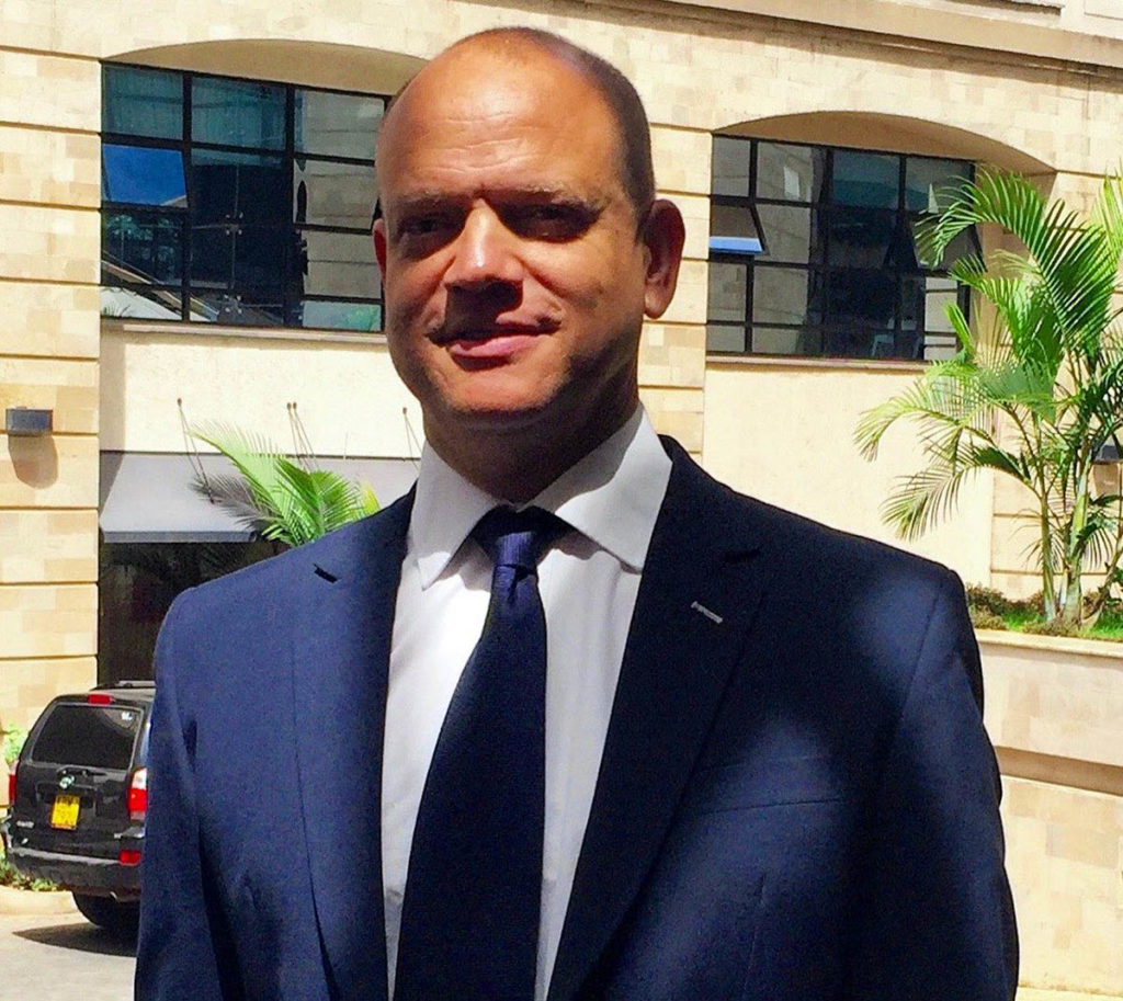 Headshot of James French, who wears a blue suit and tie.