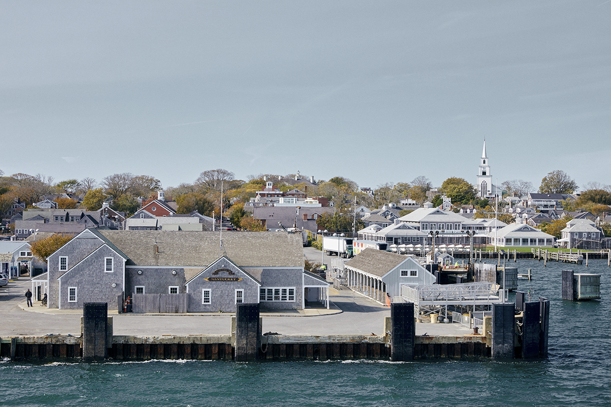 Terminal for ferry above water with town houses behind.