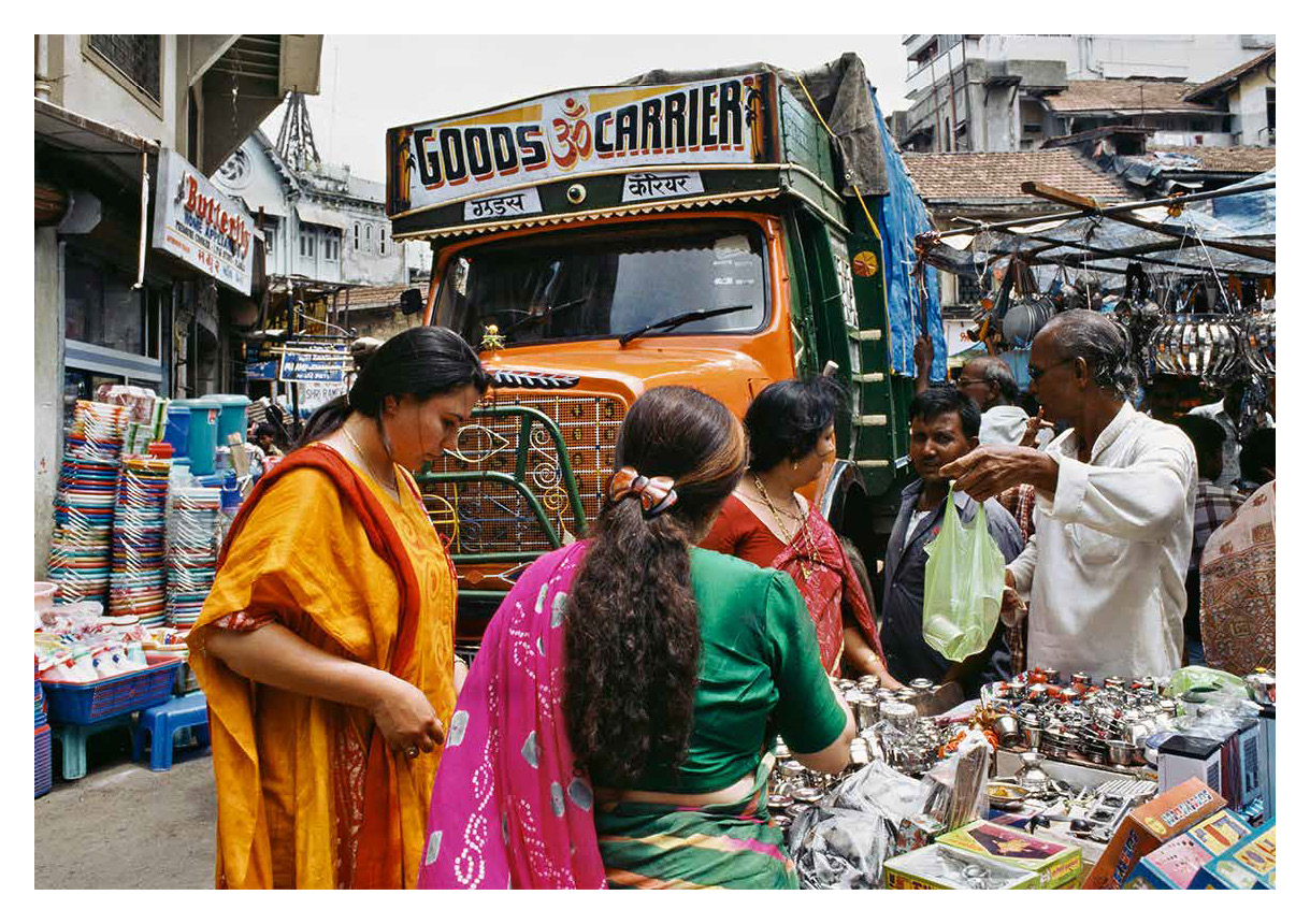 Spread from 'The Kinetic City and Other Essays' of two women buying from informal store in the streets of India