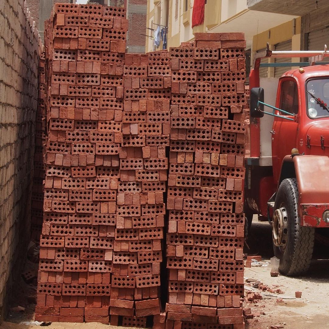 A pile of bricks next to a construction truck.