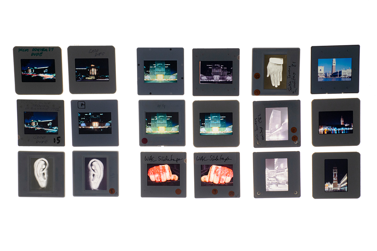 A detail of the light table showing a collection of slides of buildings, monuments, and close ups of human hands and ears.
