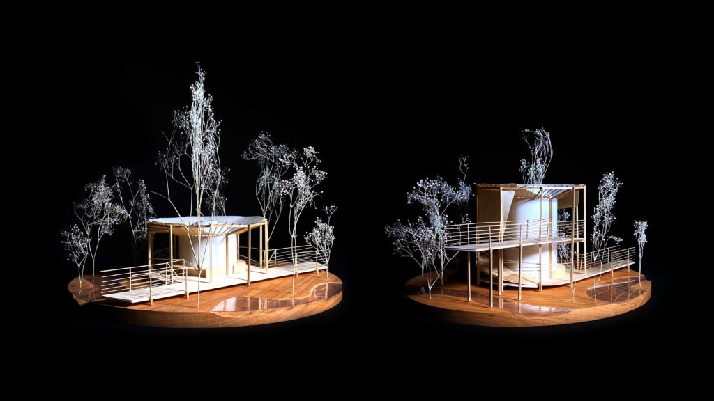 Two models of pavilions surrounded by trees and an elevated walkway.