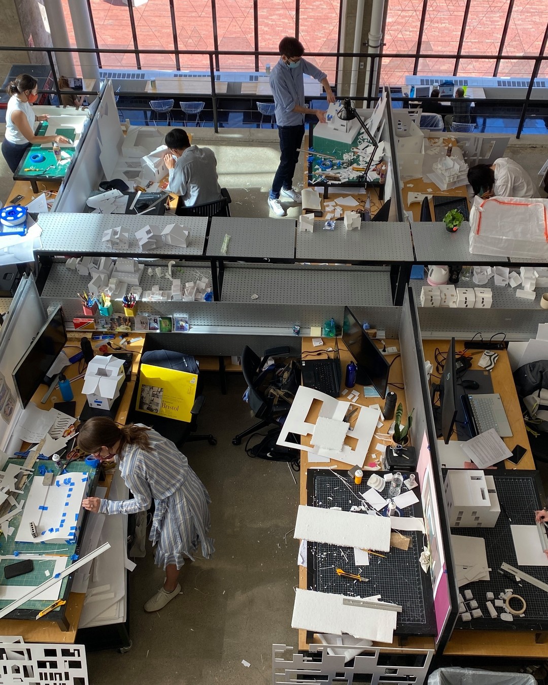 Students seen from above working at messy desks.
