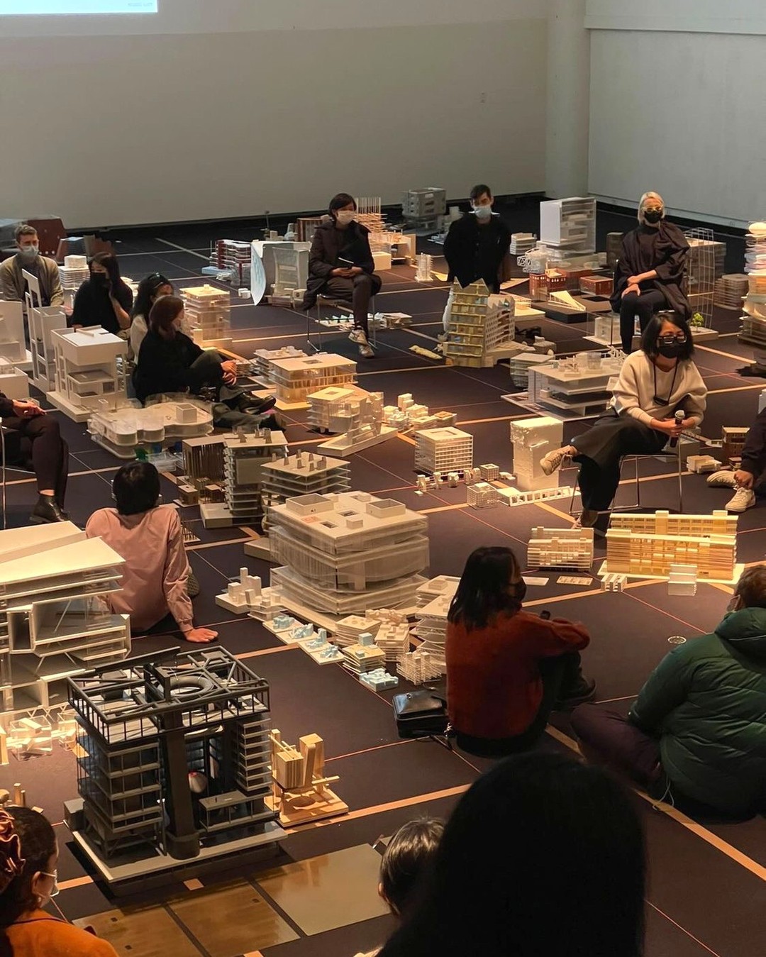 Students and faculty sit among models in Piper Auditorium.