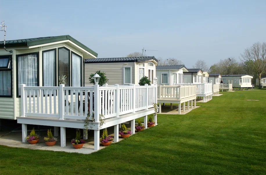 4 manufactured homes with porches on a grassy lawn