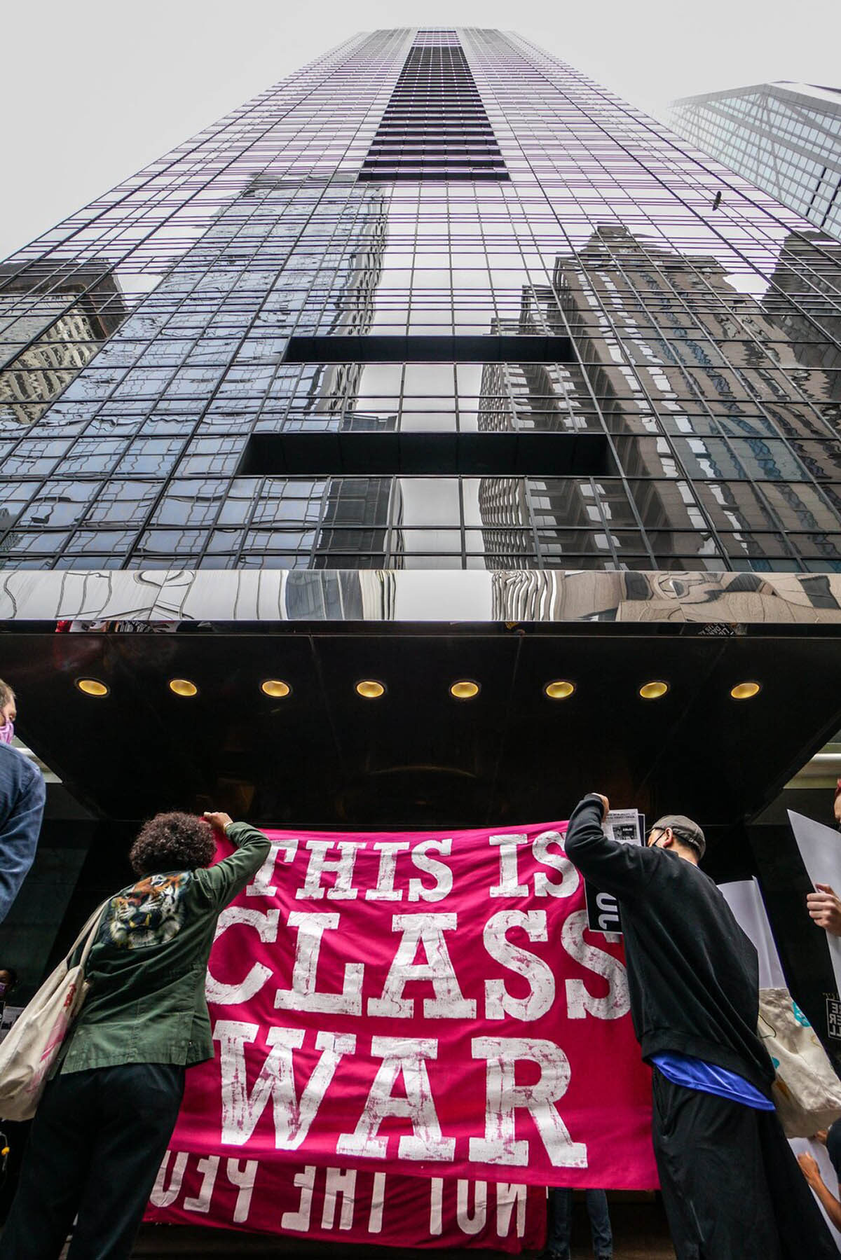 Two people hold up a sign that reads 