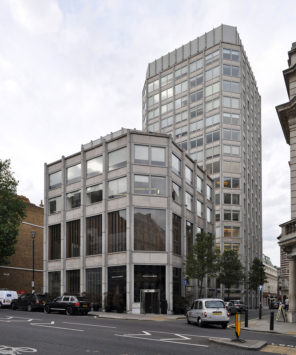 Corner view of office building defined by glass curtain walls and concrete.