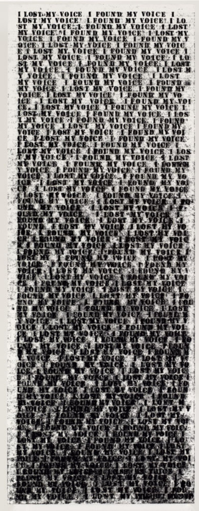 The text "I lost my voice. I found my voice" printed on a long canvas starts to overlap itself until the bottom is unreadable smudged text.