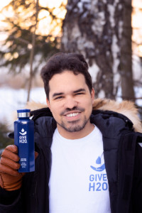 Man in fur trim coat holding blue water bottle