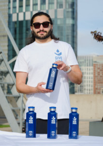 Man in white shirt holding blue bottle