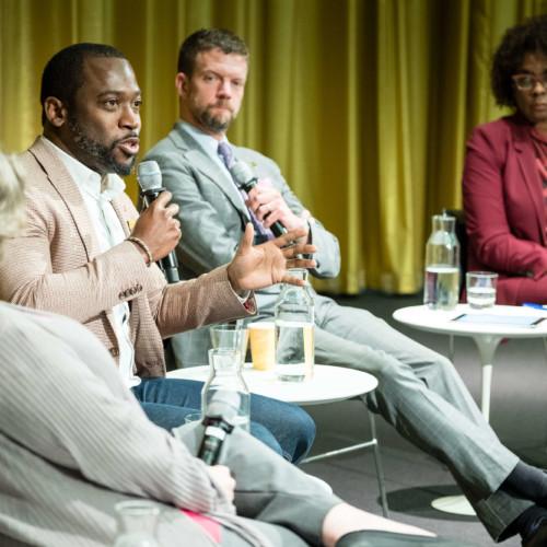 Levar M. Stoney speaks into a microphone surrounded by three other panelists.