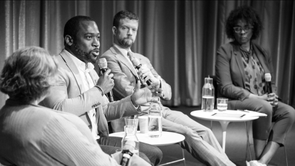 Four people sitting at a table speaking