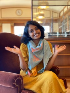 Portrait of Naksha Satish shrugging playfully.